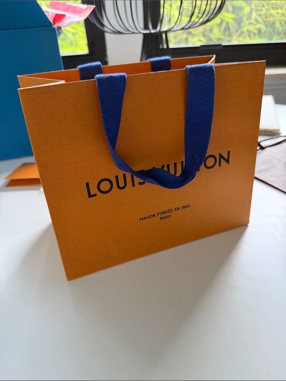 Louis Vuitton orange shopping bag with blue handles